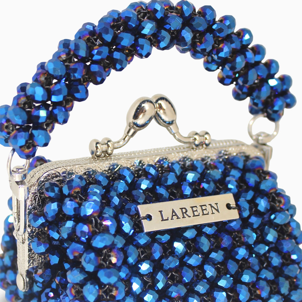 Close-up of blue beadwork and LAREEN ATELIER plaque on Aurélia Midnight Mini